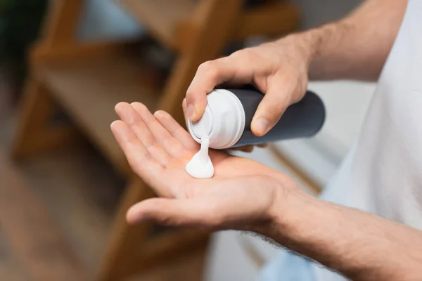 Vue partielle de l'homme appliquant de la mousse à raser sur la main — Photo de stock