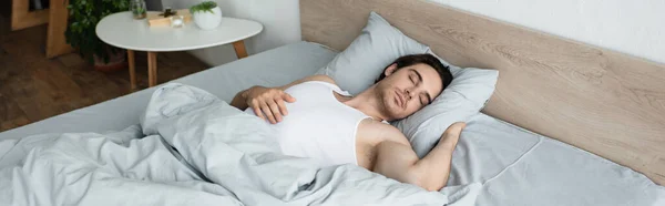 Jeune homme brune dormant sur la literie bleue le matin, bannière — Photo de stock