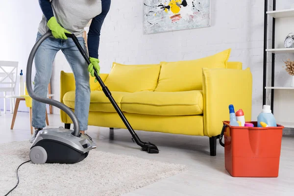 Vista ritagliata dell'uomo in guanti di gomma pulizia pavimento vicino secchio con detergenti — Foto stock