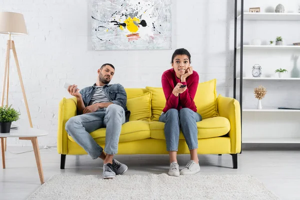 Africano americano mulher assistindo tv perto namorado com smartphone em casa — Fotografia de Stock