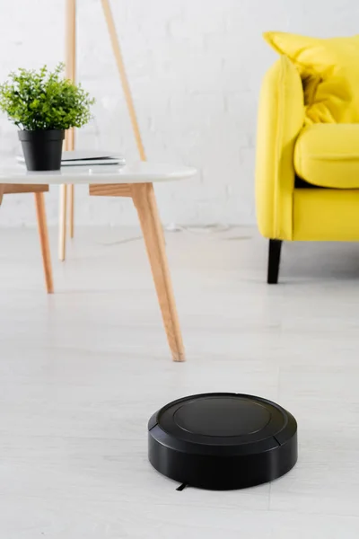 Robotic vacuum cleaner on floor in blurred living room — Stock Photo