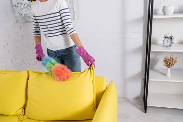 Cropped view of woman cleaning couch during housework — Stock Photo
