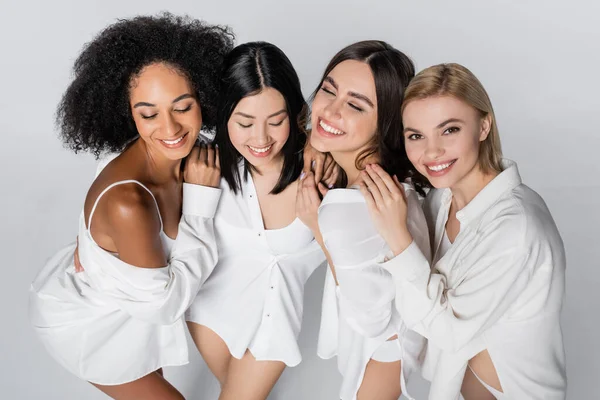 Vista de ángulo alto de los modelos multiétnicos felices sonriendo aislado en gris — Stock Photo