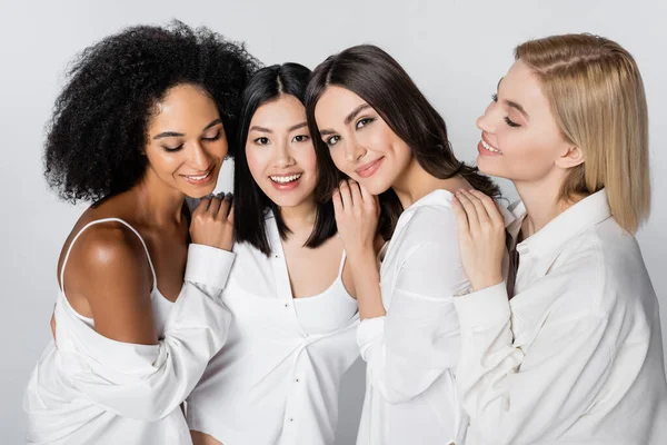 Grupo de modelos multiétnicos satisfechos posando aislados en gris — Stock Photo