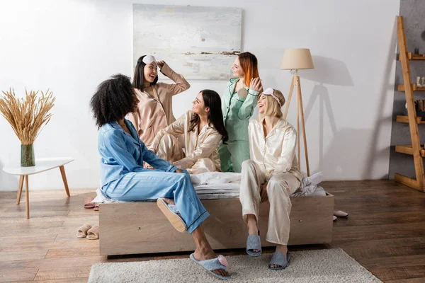 Group of happy interracial friends in pajamas during slumber party — Stock Photo