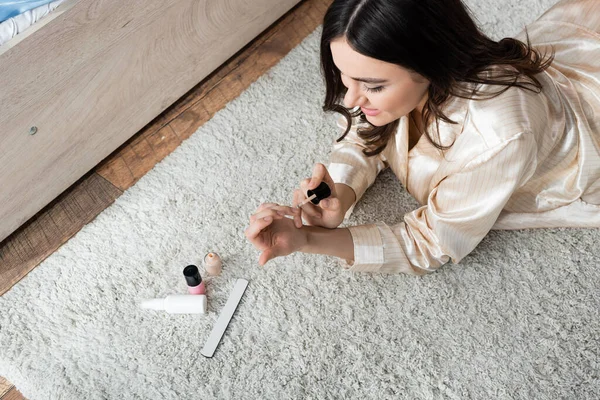 High angle view of cheerful brunette woman doing manicure — Stock Photo