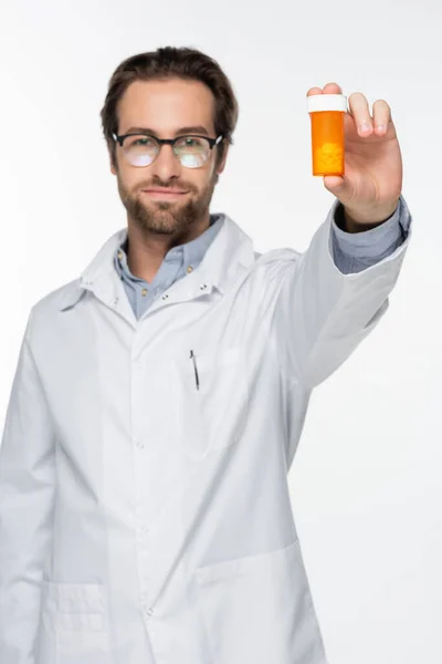 Physician in white coat showing container with medical cannabis pills isolated on white — Stock Photo