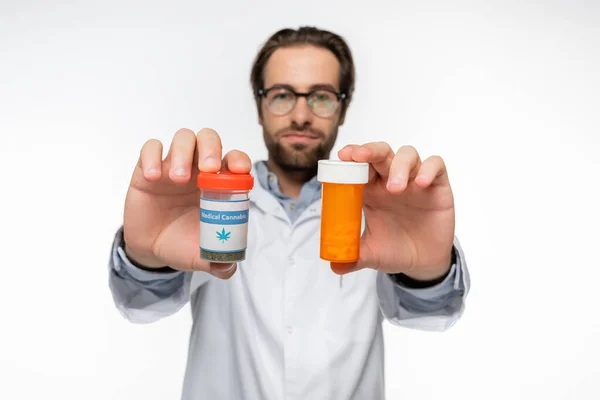 Médico borroso con envases de medicamentos hechos de cannabis medicinal aislado en blanco - foto de stock