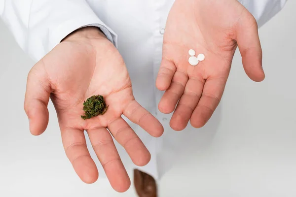 Vue partielle du médecin avec du chanvre médical sec et des pilules isolées sur blanc — Photo de stock