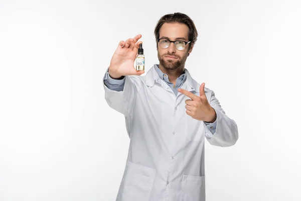 Arzt zeigt mit dem Finger auf Fläschchen mit cbd-Öl isoliert auf weiß — Stockfoto