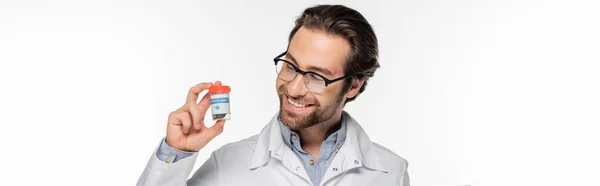 Happy doctor looking at container with medical cannabis isolated on white, banner — Stock Photo