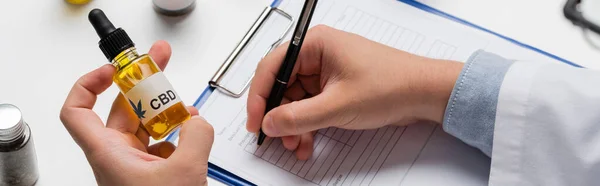 Partial view of physician with cbd oil writing prescription, banner — Stock Photo