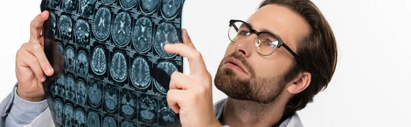 Doctor in eyeglasses looking at mri scan isolated on white, banner — Stock Photo