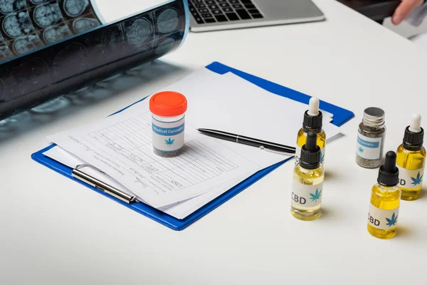 Mri scan cerca de medicamentos recetados y medicinales de cannabis en escritorio blanco - foto de stock