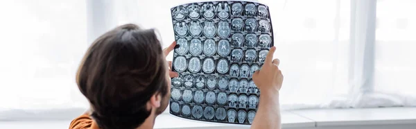 Man looking at mri scan against window at home, banner — Stock Photo