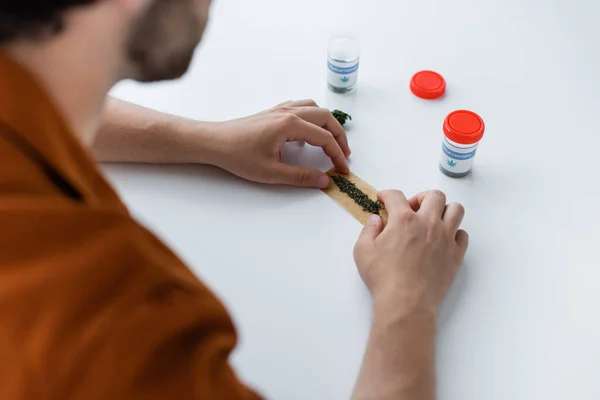 Cropped view of diseased man making joint with medical hemp at home — Stock Photo