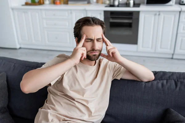 Mann hält Finger in Stirnnähe, während er unter Kopfschmerzen leidet — Stockfoto