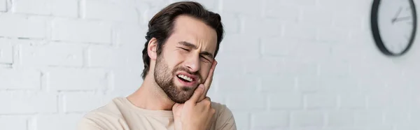 Mann berührt Wange, während er unter Zahnschmerzen leidet, Banner — Stockfoto