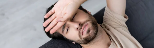 Vista superior del hombre enfermo tocando la frente en casa, pancarta - foto de stock