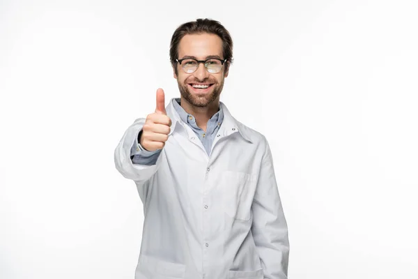 Alegre médico mostrando el pulgar hacia arriba aislado en blanco - foto de stock