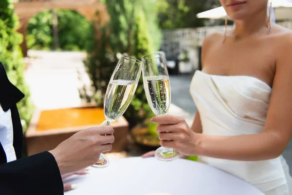 Cropped view of lesbian couple toasting with champagne during wedding outdoors — Stock Photo