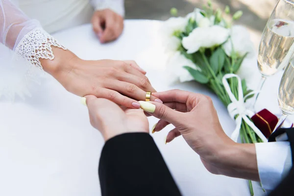 Обрізаний вид лесбіянки в золотому кільці на пальці подруги біля шампанського під час весілля — стокове фото