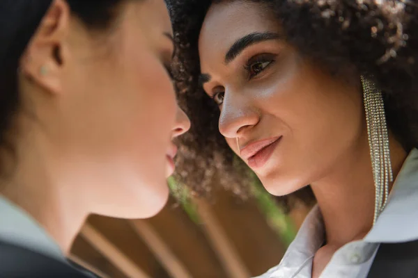 Low angle view of african american woman looking at blurred girlfriend outdoors — Stock Photo