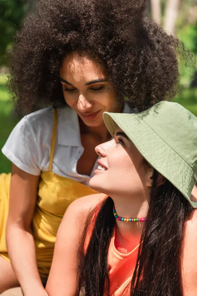 Smiling woman looking at african american girlfriend outdoors — Stock Photo