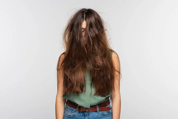 Молода жінка з заплутаним довгим волоссям ізольована на сірому — стокове фото