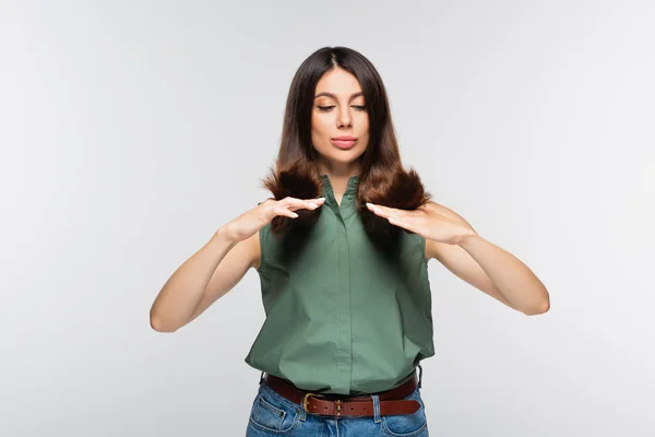 Junge Frau blickt auf Haare endet isoliert auf grau — Stockfoto