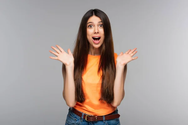 Amazed young woman with long hair looking at camera isolated on grey — Stock Photo
