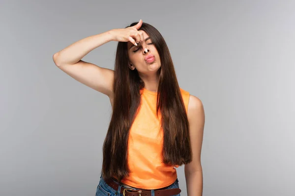 Young woman pouting lips and grimacing isolated on grey — Stock Photo