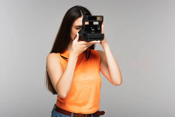 Jovem mulher tirando foto na câmera vintage isolado em cinza — Fotografia de Stock