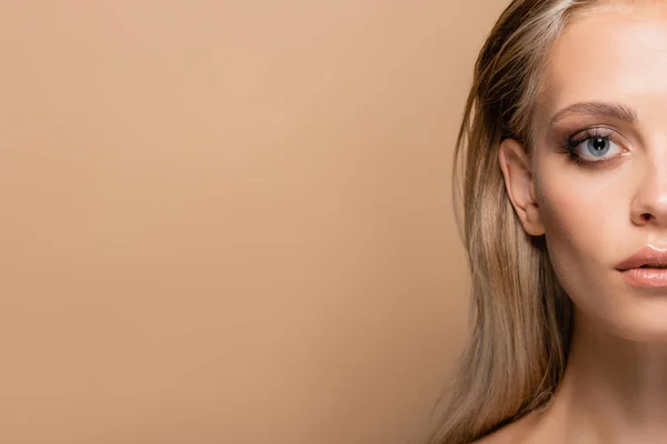 Cropped view of young blonde woman with makeup isolated on beige with copy space — Stock Photo