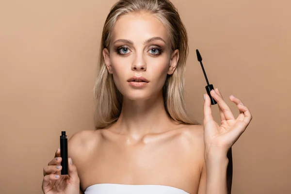 Sensual young woman with black mascara looking at camera isolated on beige — Stock Photo