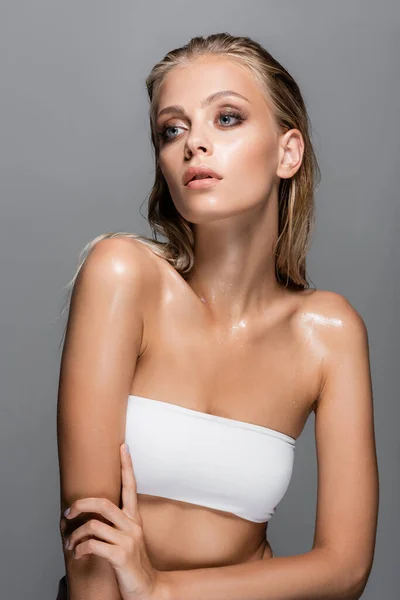 Wet woman with perfect skin and makeup looking away isolated on grey — Stock Photo