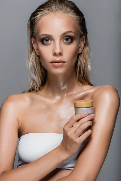 Donna con pelle bagnata e capelli con crema cosmetica isolata su grigio — Foto stock