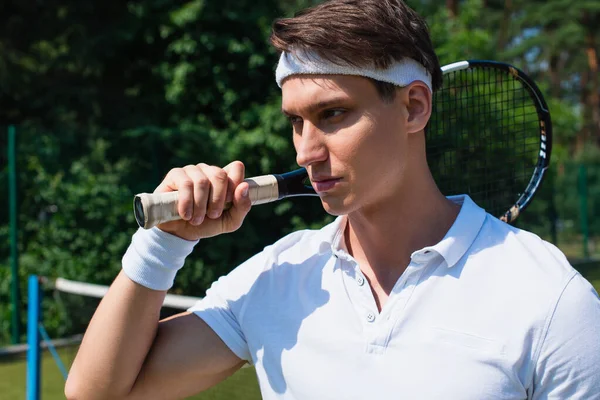 Jugador de tenis en ropa deportiva blanca con raqueta en la cancha - foto de stock