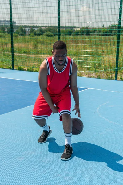 Jovem jogador afro-americano com treinamento de bola de basquete no playground — Fotografia de Stock