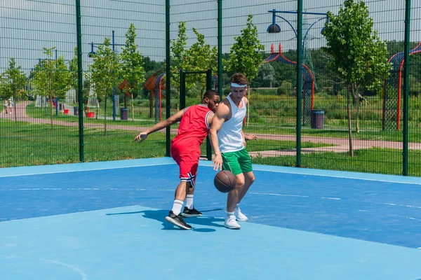 Multiethnic friends playing streetball outdoors — Stock Photo