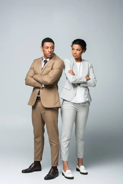 Comprimento total de afro-americanos empresários de pé com braços cruzados em cinza, conceito de igualdade de gênero — Fotografia de Stock