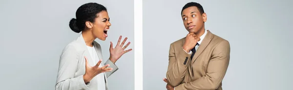 African american businesswoman screaming near wall and pensive businessman on grey, banner — Stock Photo