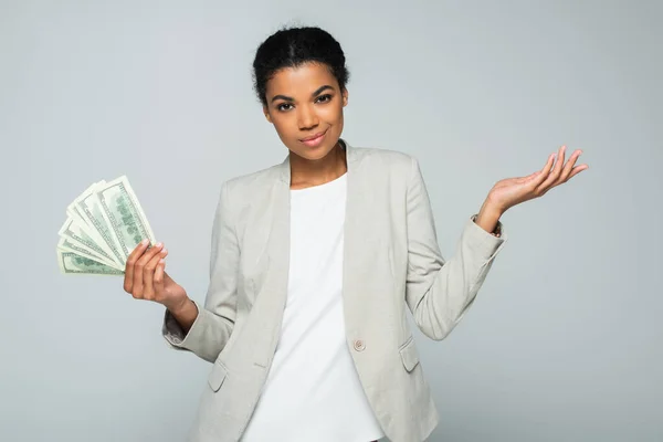 Sorridente empresária afro-americana segurando notas de dólar isoladas em cinza — Fotografia de Stock