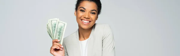 Felice donna d'affari africana americana con banconote in dollari isolate su grigio, striscione — Foto stock
