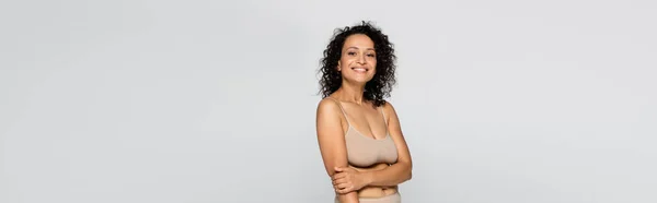 Cheerful african american woman in bra looking at camera isolated on grey, banner — Stock Photo