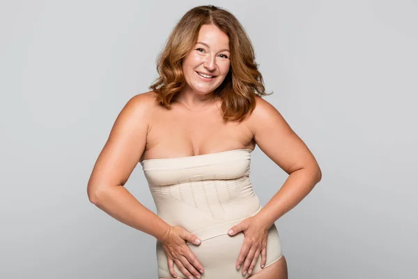 Smiling woman in underwear looking at camera isolated on grey, body positive concept — Stock Photo
