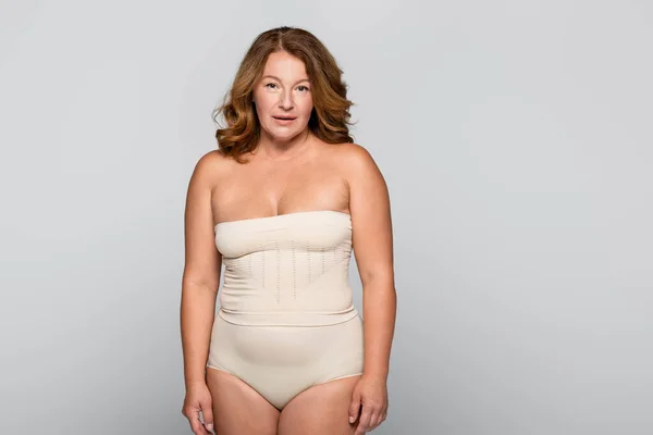 Frau mit Übergewicht blickt in Kamera isoliert auf grau — Stockfoto