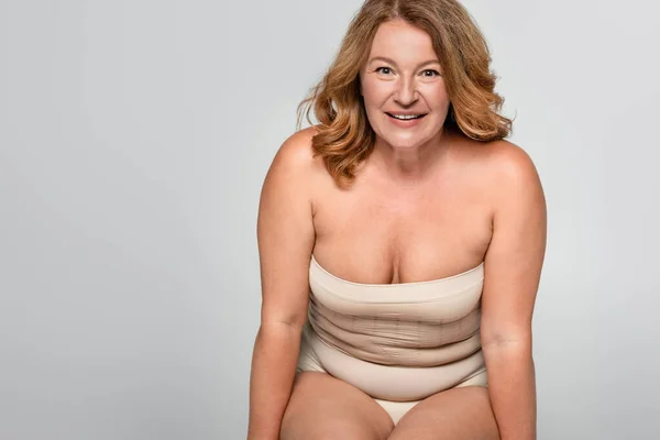 Mulher sorridente com sobrepeso olhando para câmera isolada em cinza, conceito positivo para o corpo — Fotografia de Stock
