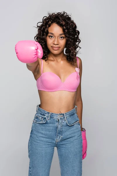 African american woman with ribbon of breast cancer and boxing gloves isolated on grey — Stock Photo