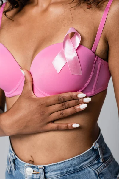 Cropped view of african american woman with pink ribbon on bra isolated on grey — Stock Photo